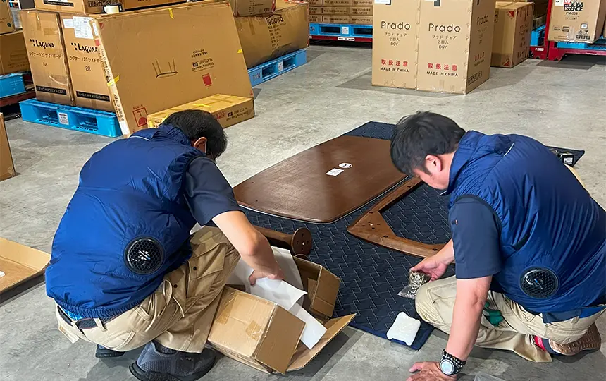 物流センター内にて撮影用のインテリア商品を組立ています。